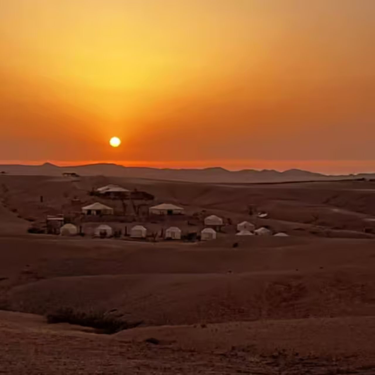 The sun setting over a dry desert landscape