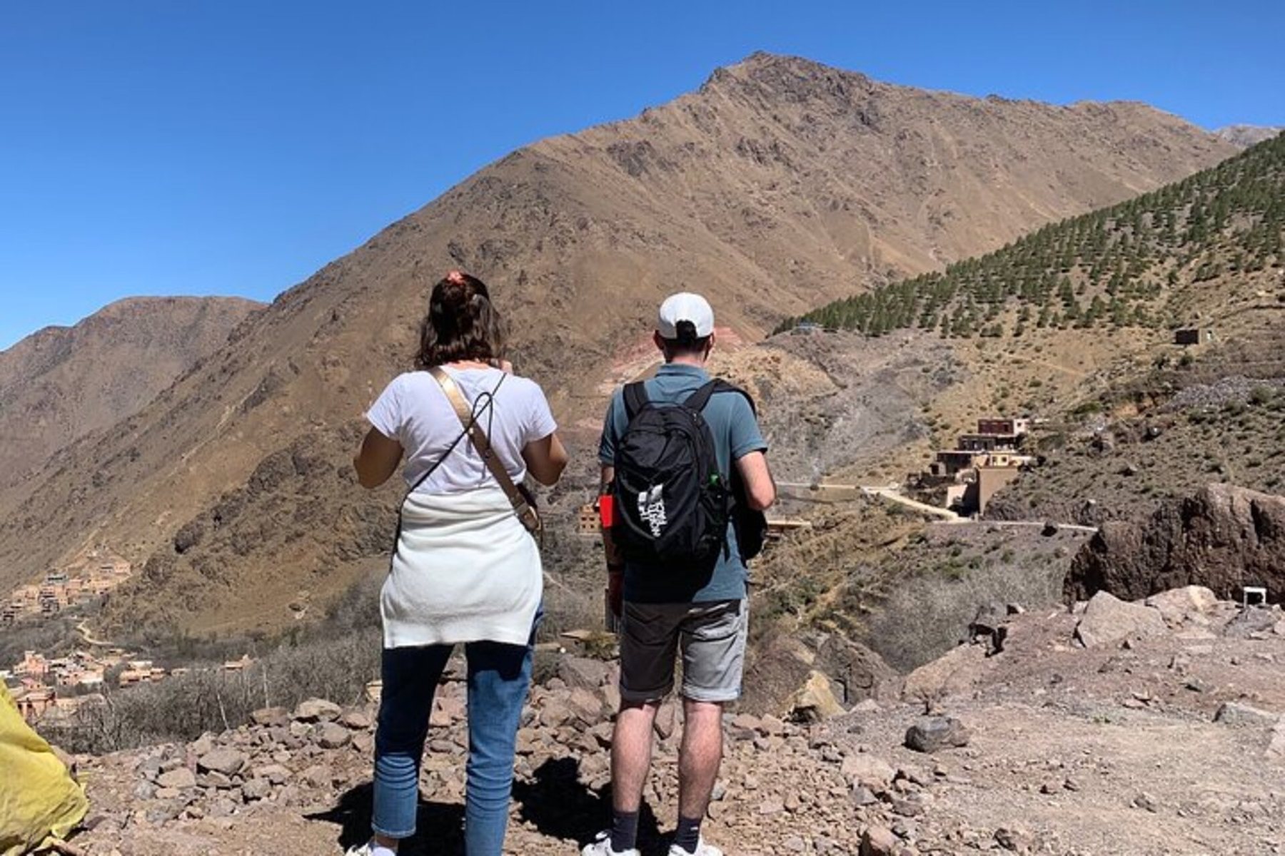 Two hikers looking towards a High Atlas village