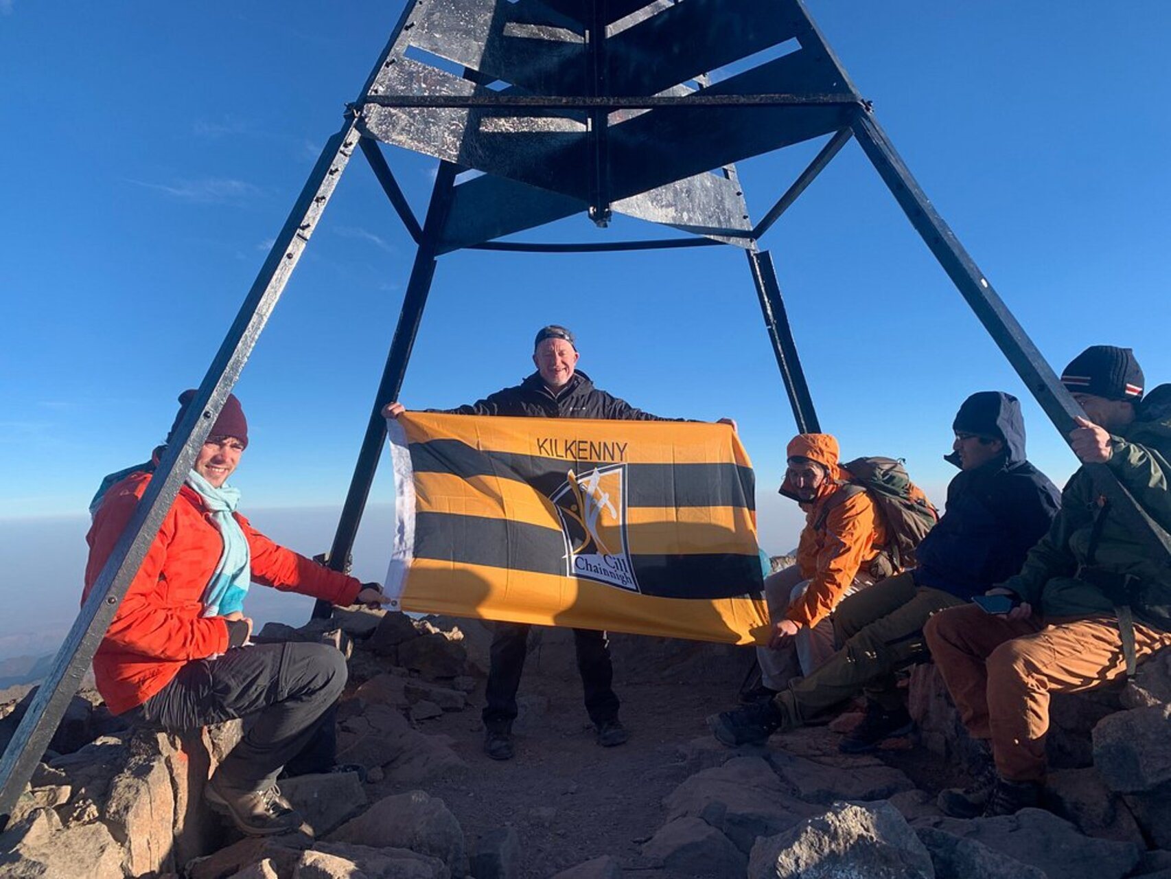 Hikers holding a flag at the summit